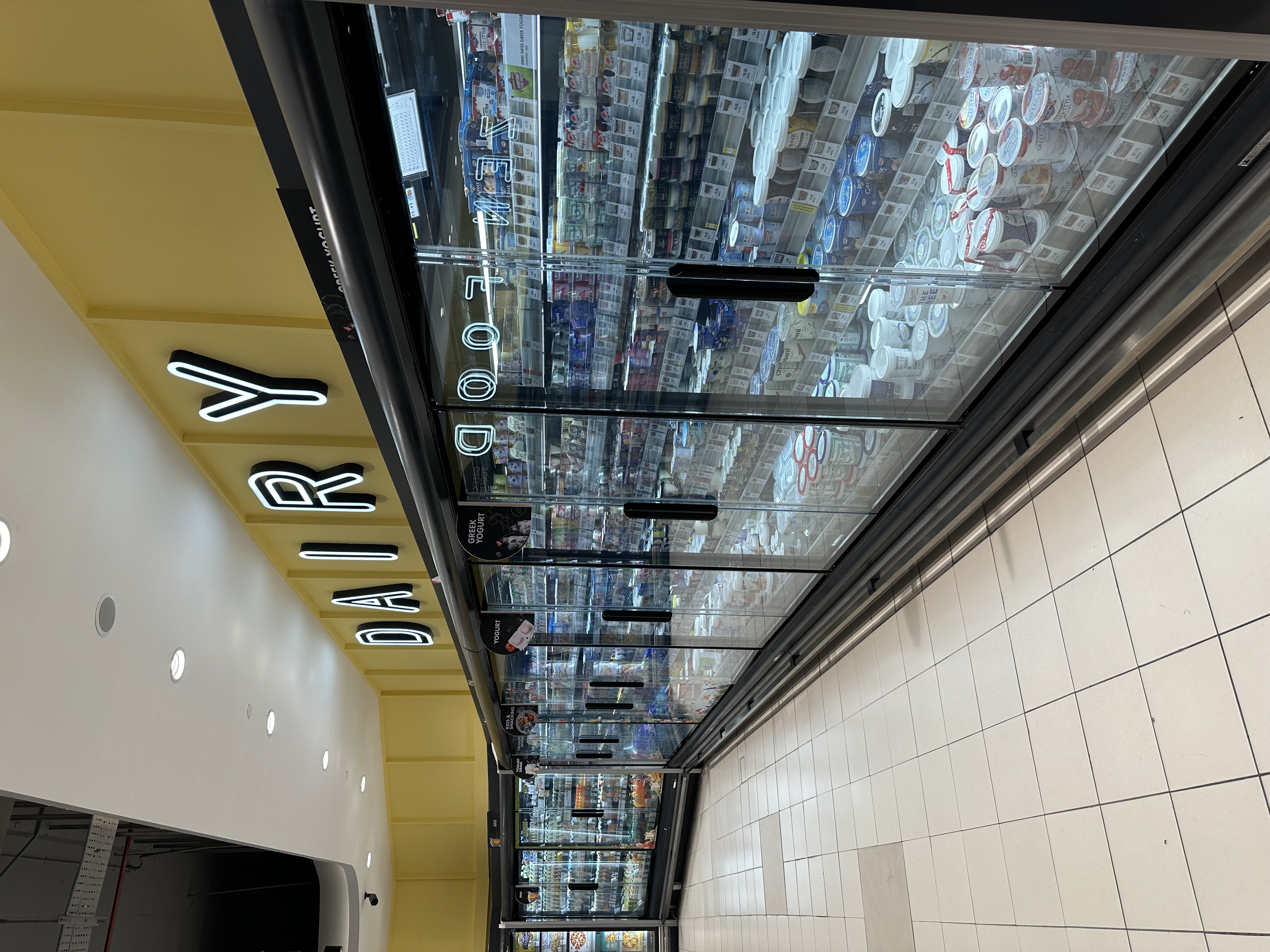Las puertas de vidrio sin marco SHHAG mejoran la exhibición de productos lácteos en la refrigeración de supermercados